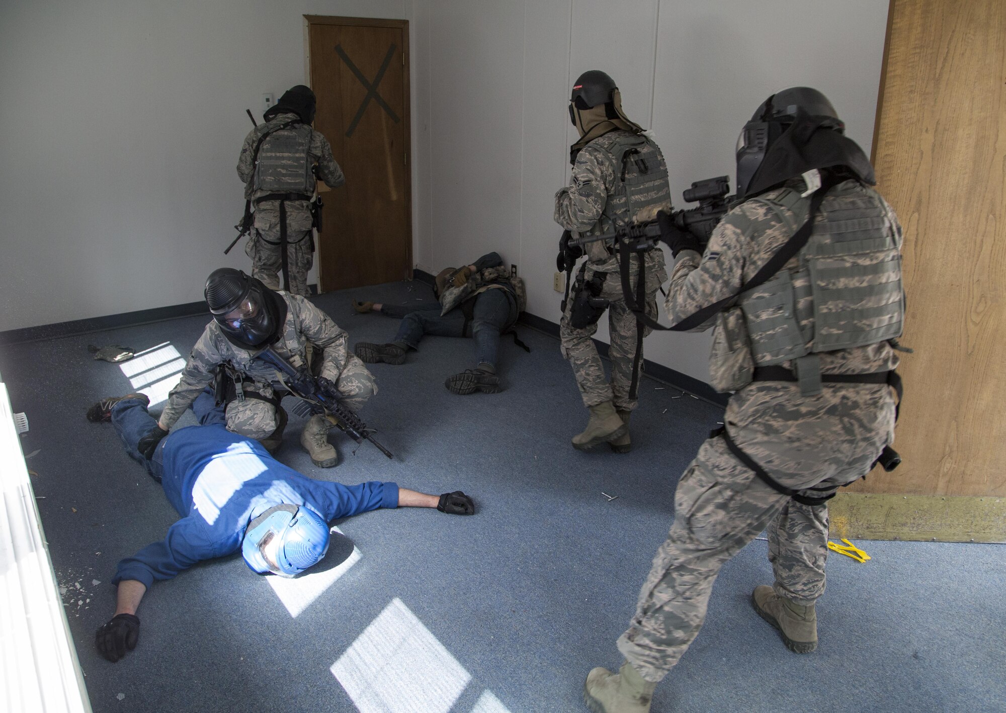 Security forces personnel, assigned to the 673d Security Forces Squadron, search and clear a building of active threats while conducting high risk response training at Joint Base Elmendorf-Richardson, Alaska, June 29, 2016. High risk response training provides security forces personnel an intensive, hands-on course based in various real-life scenarios emphasizing effective tactics to engage and eliminate active shooters or other threats. (U.S. Air Force photo/Alejandro Pena)