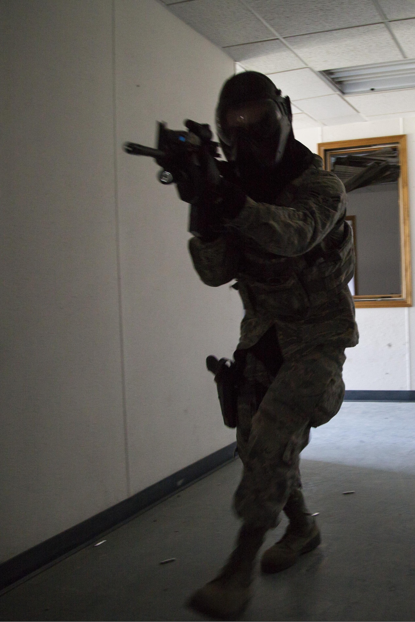 A security forces Airman, assigned to the 673d Security Forces Squadron, searches and clears a building of active threats while conducting high risk response training at Joint Base Elmendorf-Richardson, Alaska, June 29, 2016. High risk response training provides security forces personnel an intensive, hands-on course based in various real-life scenarios emphasizing effective tactics to engage and eliminate active shooters or other threats. (U.S. Air Force photo/Alejandro Pena)