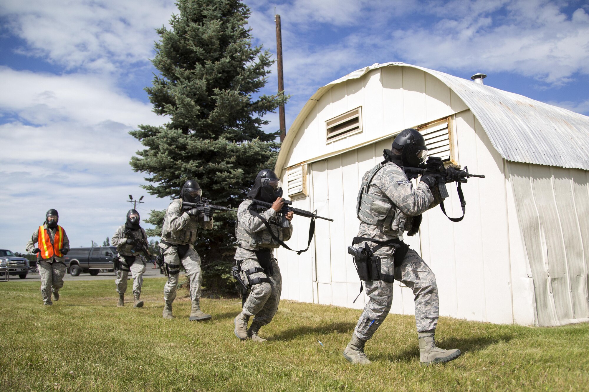 Security forces personnel, assigned to the 673d Security Forces Squadron, rush to breach a building while conducting high risk response training at Joint Base Elmendorf-Richardson, Alaska, June 29, 2016. High risk response training provides security forces personnel an intensive, hands-on course based in various real-life scenarios emphasizing effective tactics to engage and eliminate active shooters or other threats. (U.S. Air Force photo/Alejandro Pena)