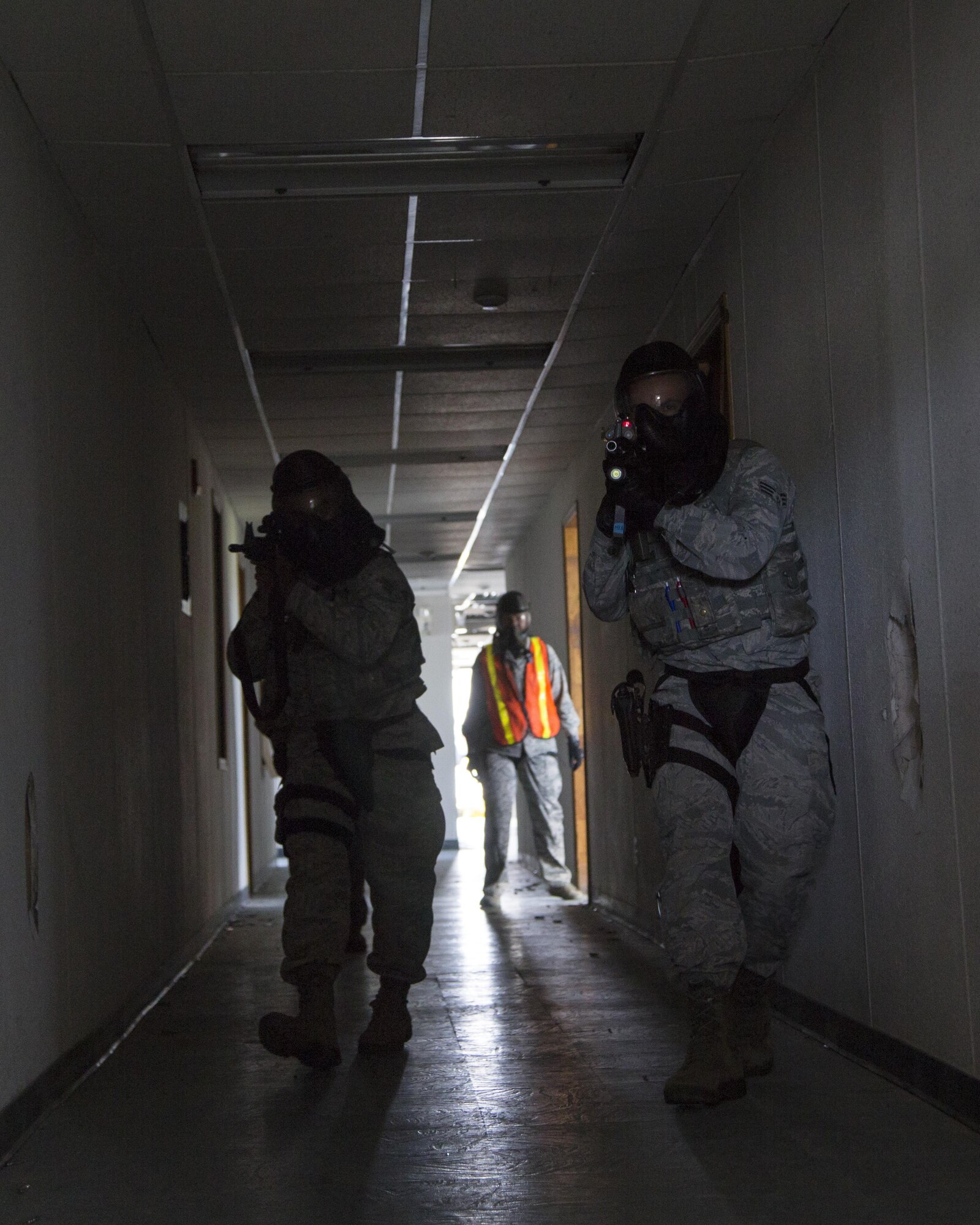 Security forces personnel, assigned to the 673d Security Forces Squadron, rush to breach a building while conducting high risk response training at Joint Base Elmendorf-Richardson, Alaska, June 29, 2016. High risk response training provides security forces personnel an intensive, hands-on course based in various real-life scenarios emphasizing effective tactics to engage and eliminate active shooters or other threats. (U.S. Air Force photo/Alejandro Pena)