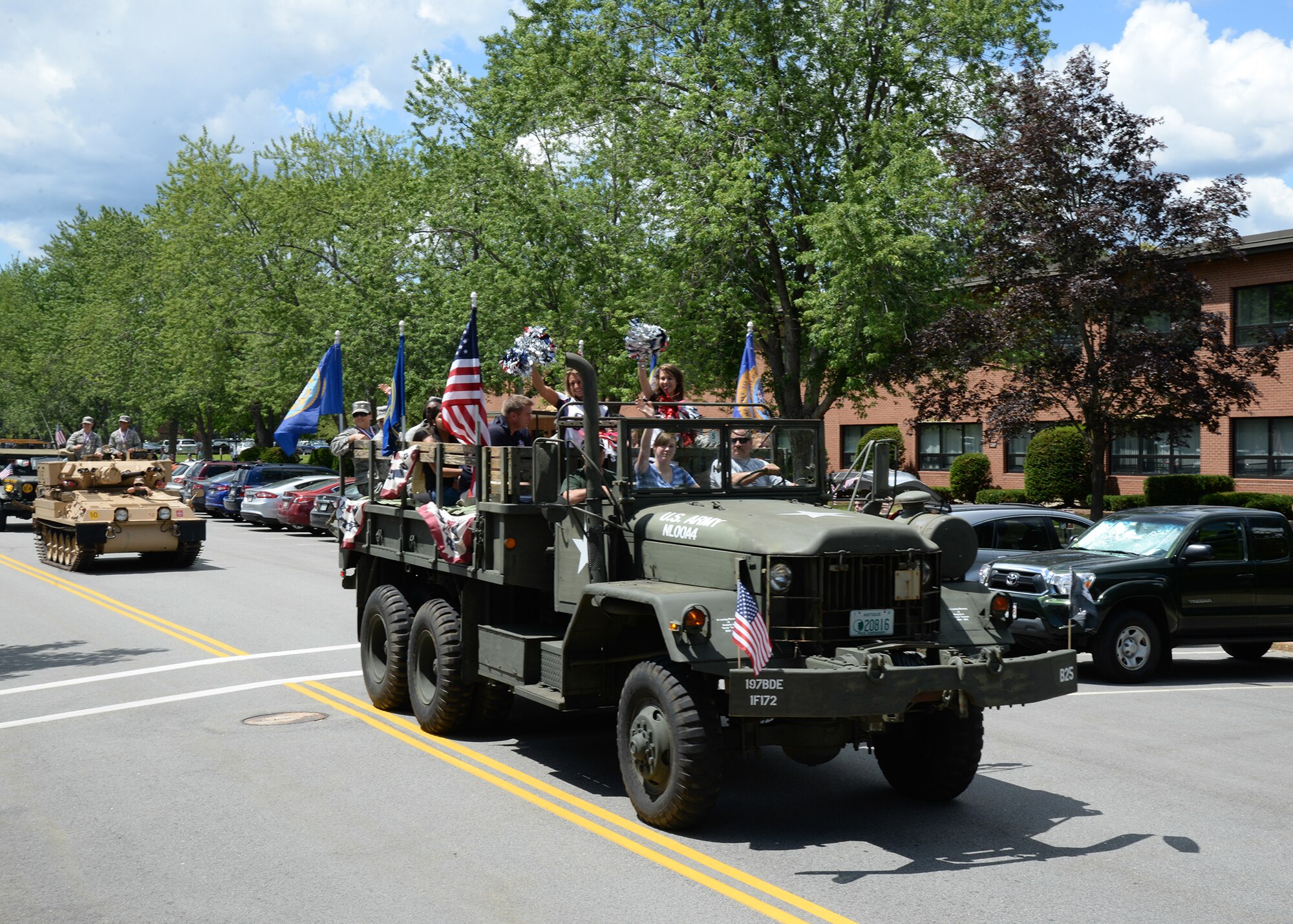 Parade participants smile and wave from a vintage military vehicle during a Heroes Homecoming celebration on base July 23, 2015. Hanscom personnel are invited to help welcome home more than 60 service members who have returned from deployment in the past year during the 2016 celebration to be held July 21. (U.S Air Force photo by Linda LaBonte Britt)