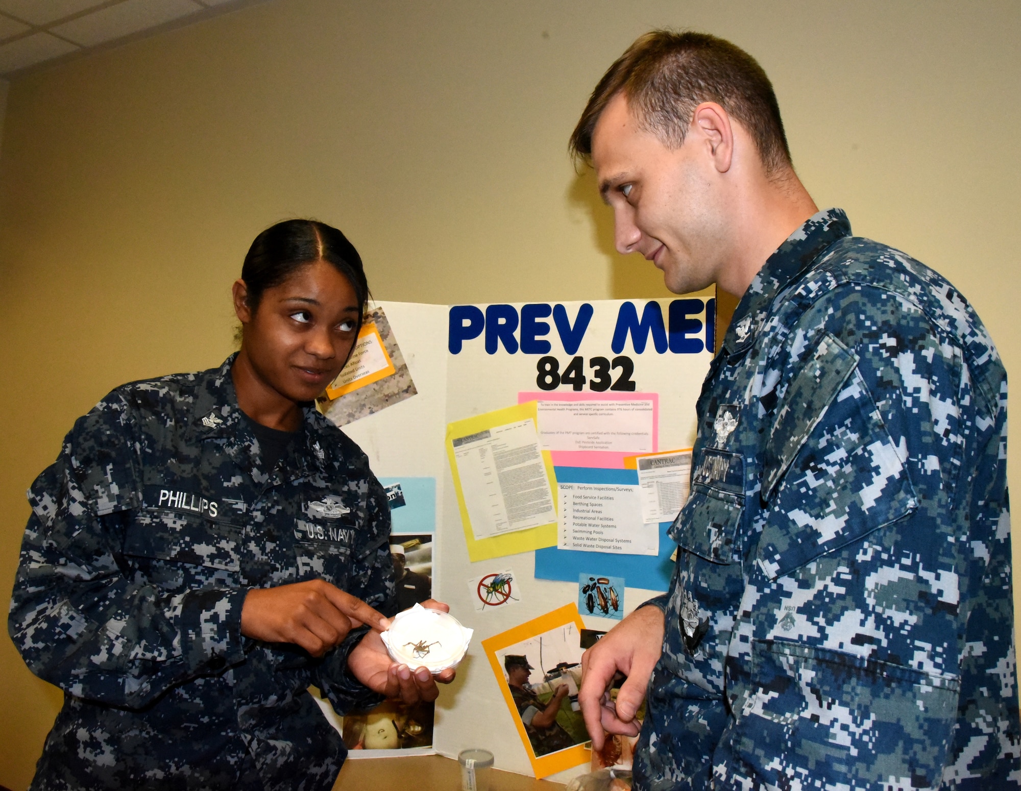 Petty Officer 1st Class Shamace Phillips, a preventive medicine technician
serving at Naval Health Clinic Charleston, exhibits a specimen of a spider
native to the Lowcountry to Petty Officer 3rd Class Brent Smith, a general
duty corpsman serving in Military Medicine at NHCC, during NHCC's Navy
Enlisted Classification Fair June 29, 2016. One of the many duties of the
preventive medicine technician is to collect and study insects in the local
area for disease prevention. During the NEC Fair, Phillips was one of many
representatives from NHCC who staffed tables filled with interactive
displays and information about the Hospital Corps, Hospital Corps
classifications and various programs available to enlisted Sailors. (Navy
photo by Kris Patterson)
