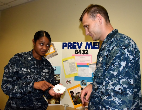Petty Officer 1st Class Shamace Phillips, a preventive medicine technician
serving at Naval Health Clinic Charleston, exhibits a specimen of a spider
native to the Lowcountry to Petty Officer 3rd Class Brent Smith, a general
duty corpsman serving in Military Medicine at NHCC, during NHCC's Navy
Enlisted Classification Fair June 29, 2016. One of the many duties of the
preventive medicine technician is to collect and study insects in the local
area for disease prevention. During the NEC Fair, Phillips was one of many
representatives from NHCC who staffed tables filled with interactive
displays and information about the Hospital Corps, Hospital Corps
classifications and various programs available to enlisted Sailors. (Navy
photo by Kris Patterson)
