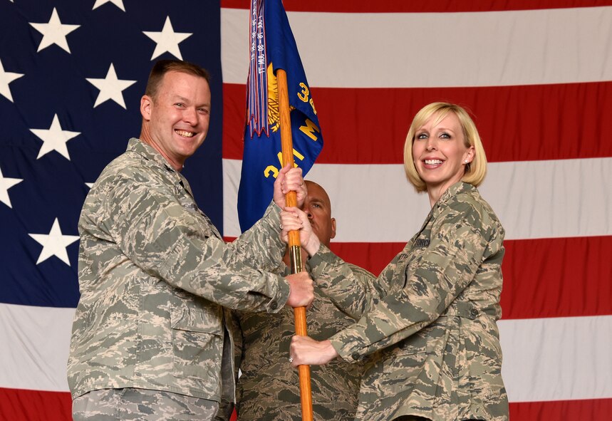 Maj. Naomi Franchetti, right, accepts command of the 341st Missile Maintenance Squadron from Col. Kenneth Speidel, 341st Maintenance Group commander, during a change of command ceremony at the Malmstrom Air Force Base 3-Bay Hangar July 5. Senior Master Sgt. Eric Butt, 341st Missile Maintenance Squadron first sergeant, looks on. (U.S. Air Force photo/Senior Airman Jaeda Tookes) 
