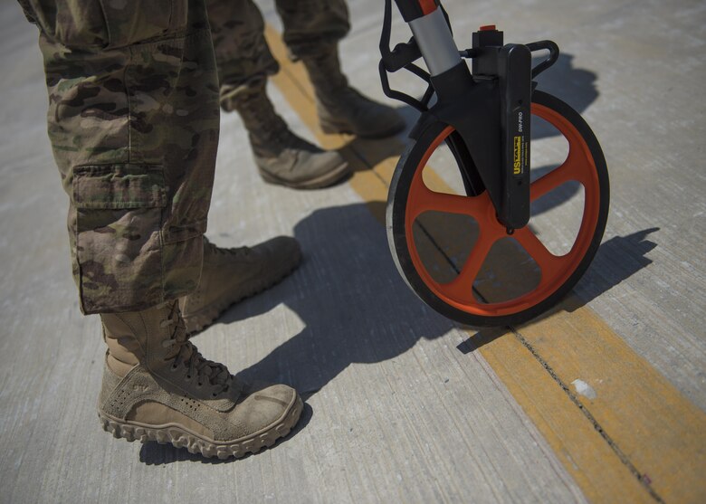 Tech. Sgt. Amy Saunders, 455th Expeditionary Operation Support Squadron, Detachment 1 airfield management liaison officer, and Capt. Laura Ryan, 455th EOSS, Det. 1, take measurements of the flightline, July 1, 2016, Jalalabad Airfield, Afghanistan. New layout plans are being created for the flightline to ensure it is within the safety codes. (U.S. Air Force photo by Senior Airman Justyn M. Freeman)

