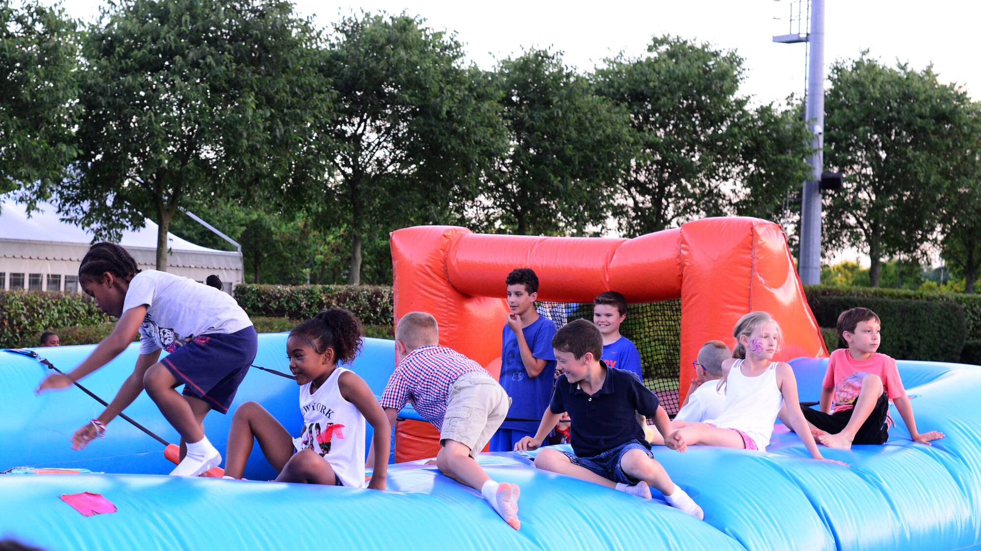 Children play on bouncy house during an Independence Day celebration at Aviano Air Base, Italy, July 4, 2016. The celebration was hosted by the 31st Fighter Wing and was open to all Team Aviano and local community members. (U.S. Air Force photo by Senior Airman Austin Harvill/Released)