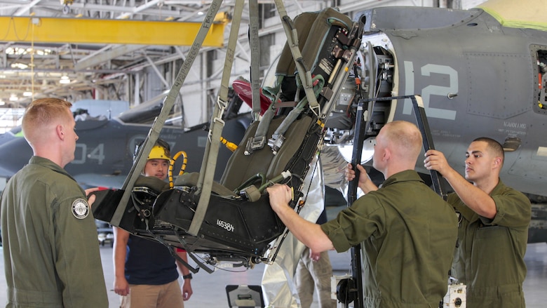 Marines with Marine Attack Squadron 231, Marine Aircraft Group 14, 2nd Marine Aircraft Wing guide an ejection seat down after removing it from an AV-8B Harrier aboard Marine Corps Air Station Cherry Point, North Carolina, June 30, 2016. By performing daily tasks and needed maintenance on the aircraft to ensure readiness, Marines maintain their squadron’s ability to deploy at a moment's notice.