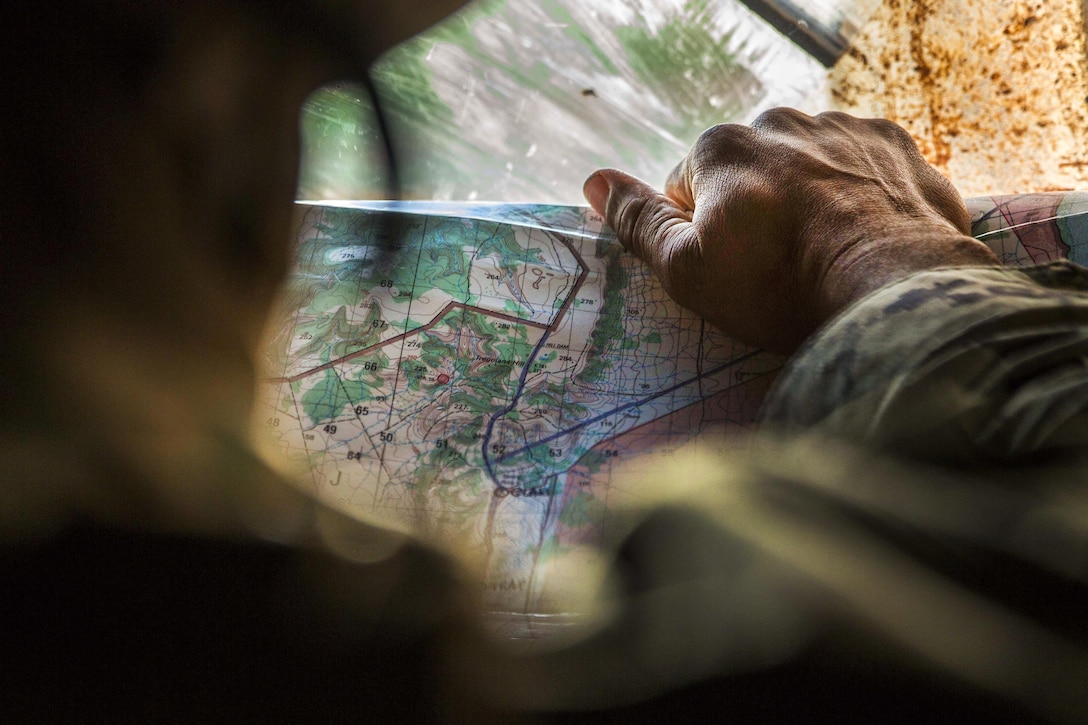 Marine Corps Gunnery Sgt. Gayle L. Anders reads a map before advancing to his next objective during Exercise Hamel at Cultana Training Area, Australia, July 1, 2016. Anders is a platoon sergeant assigned to Alpha Company, 1st Battalion, 1st Marine Regiment, Marine Rotational Force Darwin. Marine Corps photo by Cpl. Carlos Cruz Jr.