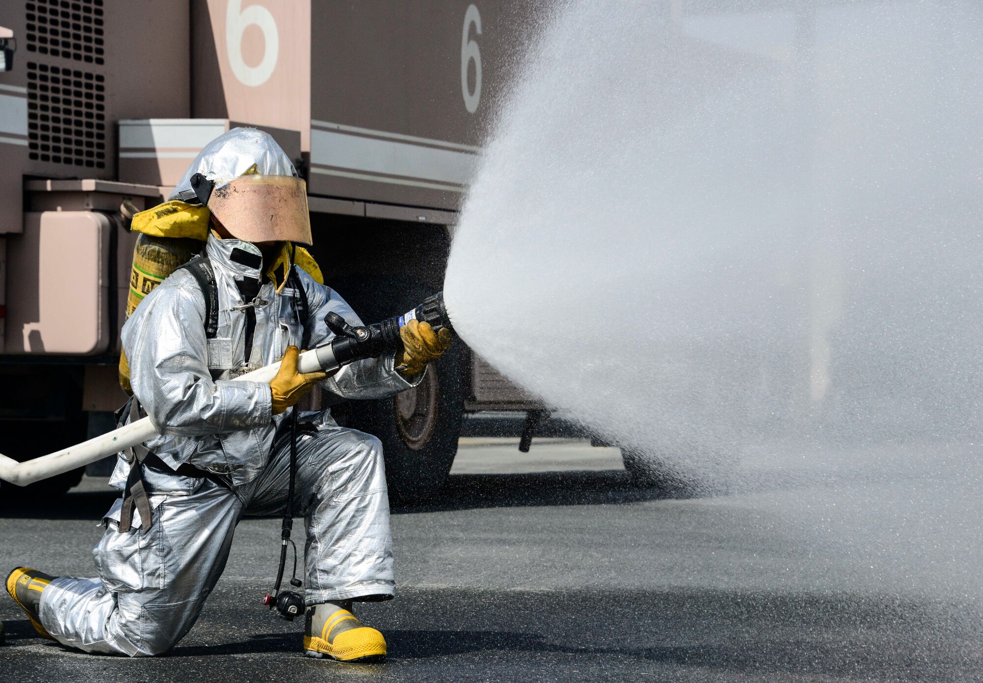 Senior Airman Dashawn Gilford, 379th Expeditionary Civil Engineer Squadron firefighter, advances a 1 ¾-inch hand line, which sprays in a fog pattern June 24, 2016, at Al Udeid Air Base, Qatar. Most Air Force and Department of Defense firefighters work 72 consecutive hours each week providing fire and emergency services to the aircraft and the base. The 379th ECES fire department works with coalition and host nation partners in support of several types of aircraft on base. (U.S. Air Force photo/Senior Airman Janelle Patiño/Released)