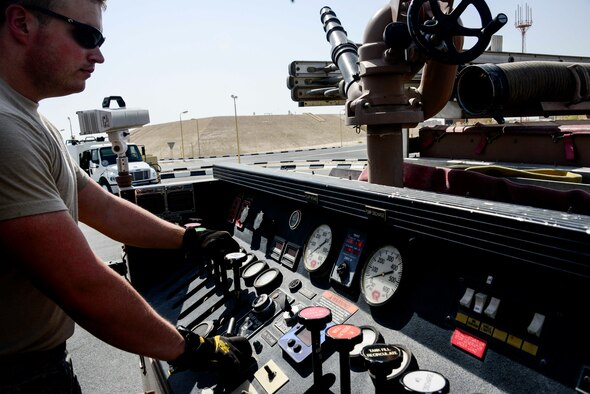 Staff Sgt. Josh Patterson, 379th Expeditionary Civil Engineer Squadron Engine 21 operator, operates the fire pump of Engine 21 June 24, 2016, at Al Udeid Air Base, Qatar. Fire pump operators go through training and classroom time to understand how a fire pump functions and how to effectively operate it. Firefighters conduct training daily to improve their response to building and aircraft fires, rescuing people from auto accidents, hazardous materials incidents, and technical rescue to prepare for different types of emergencies that can occur on base. (U.S. Air Force photo/Senior Airman Janelle Patiño/Released)