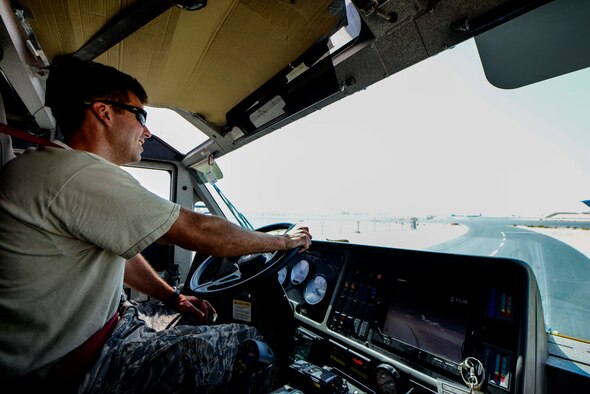 Staff Sgt. Kevin Vaughn, 379th Expeditionary Civil Engineer Squadron firefighter, operates the Oshkosh Striker crash truck on the flight line June 24, 2016, at Al Udeid Air Base, Qatar. The striker carries 3,000 gallons of water and 420 gallons of firefighting foam. It can discharge the water or foam from a roof turret, which flows 1,250 gallons per minute, or a front bumper mounted turret, which flows 300 gpm. The AUAB fire department is the busiest in the Air Force based on call volume. The warm weather here places additional stress on systems that sometimes results in the outbreak of a fire, such as motors running hotter on vehicles or electrical systems overheating when under high demand. Additionally, unlike at home station, the 379th ECES fire department works with coalition and host nation partners in support of several types of aircraft on base. (U.S. Air Force photo/Senior Airman Janelle Patiño/Released)