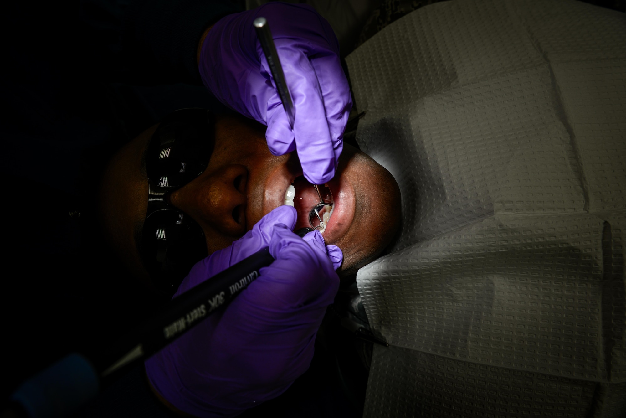 Maj. Thomas Reynolds, 86th Dental Squadron general dentist, examine the teeth of a patient July 1, 2016, at Ramstein Air Base, Germany.  The clinic sees more than 250 patients a day from across the Kaiserslautern Military Community. Not only do they ensure the dental health of those within the local area but also those at 250 geographically separated units. (U.S. Air Force photo/Senior Airman Nicole Keim) 