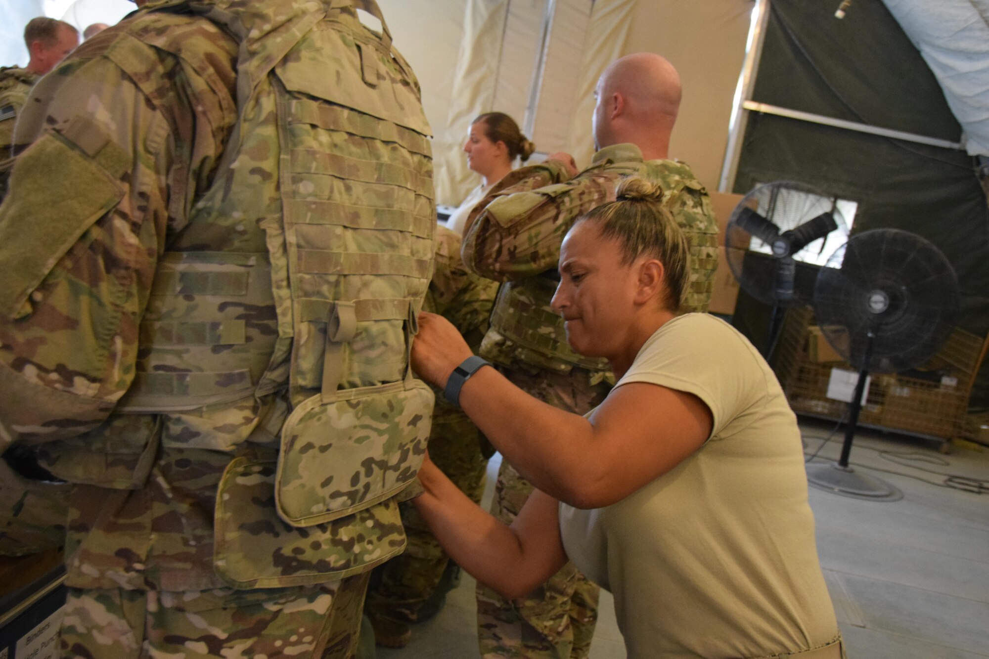 Getting the right fit is important when fitting protective equipment onto service members going downrange according to Master Sgt. Michelle Guida, Expeditionary Theater Distrbution Center superintendant, as she adjusts body armor to a customer June 23, 2016 at Al Udeid Air Base, Qatar.  The ETDC is part of the 379th Logistics Readiness Squadron, and is the busiest one in the Air Force Guida said. (U.S. Air Force photo by Technical Sgt. Carlos J. Trevino/Released)
