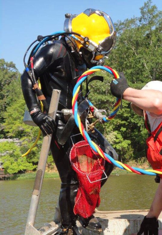 Dive team member Mike Thron returns to the boat after collecting mussel samples in a proposed dredging area.