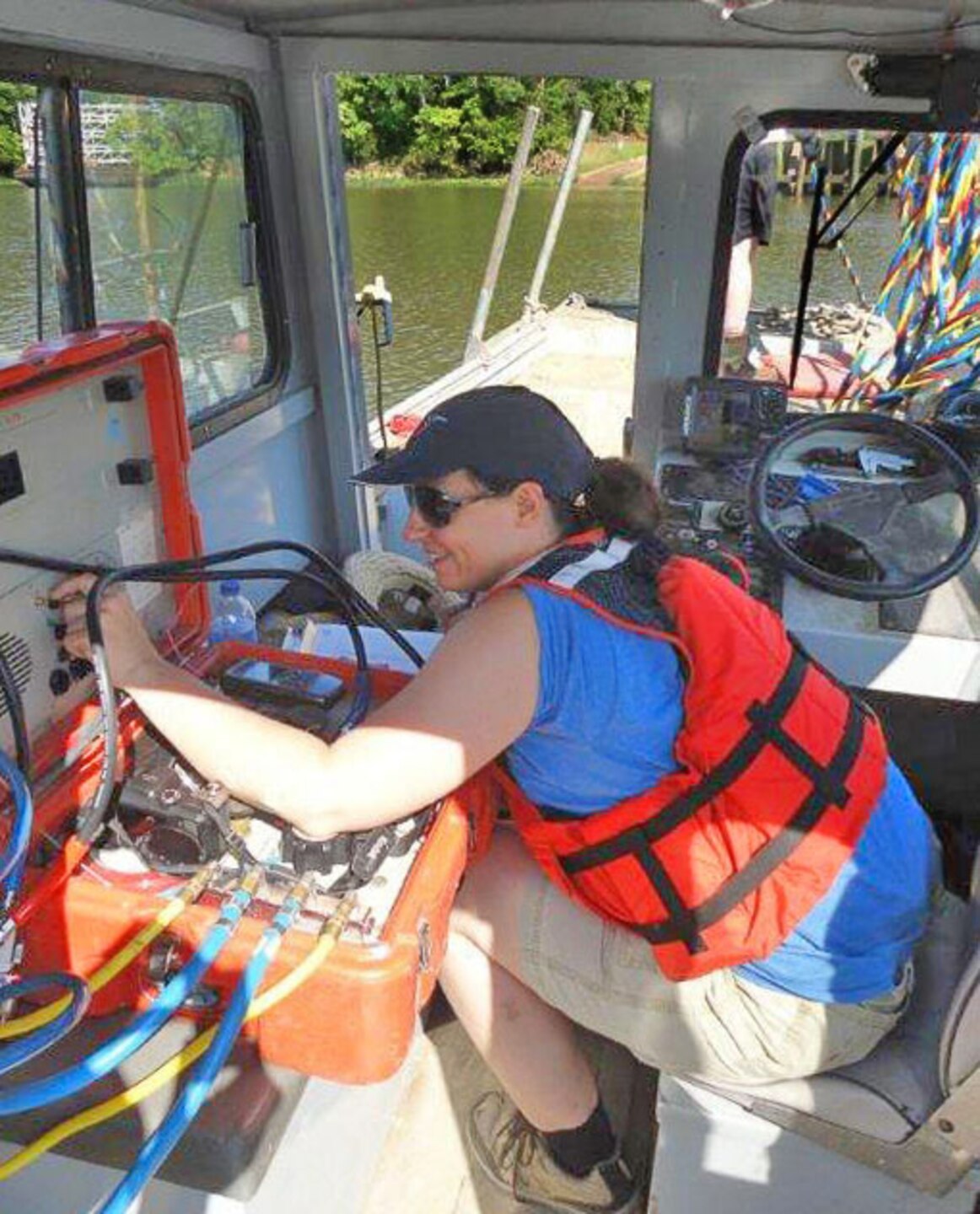 Dive team member, Andrea Carpenter, a fish and wildlife biologist, monitors the dive control station as the dive supervisor. She maintains communication with diver, Mike Thron, and monitors his air supply.