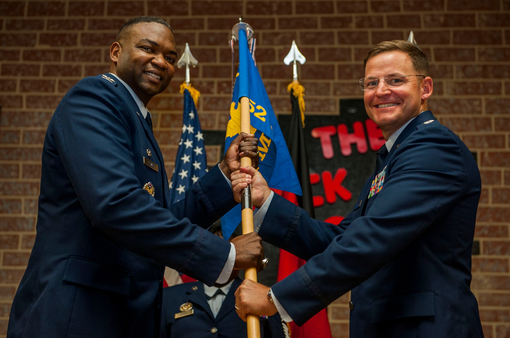 U.S. Air Force Col. Alfred Flowers, 52nd Medical Group commander, left, gives the ceremonial guidon to U.S. Air Force Lt. Col. Thomas Lesnick, incoming 52nd Medical Support Squadron commander, during the 52nd MDSS change of command ceremony in the Brickhouse on Spangdahlem Air Base, Germany, June 30, 2016. Lesnick assumed command from U.S. Air Force Lt. Col. Wade Adair, outgoing 52nd MDSS commander, under the overseeing authority of Flowers and formally greeted his new squadron for the first time during the ceremony. (U.S. Air Force photo by Airman 1st Class Timothy Kim/Released)