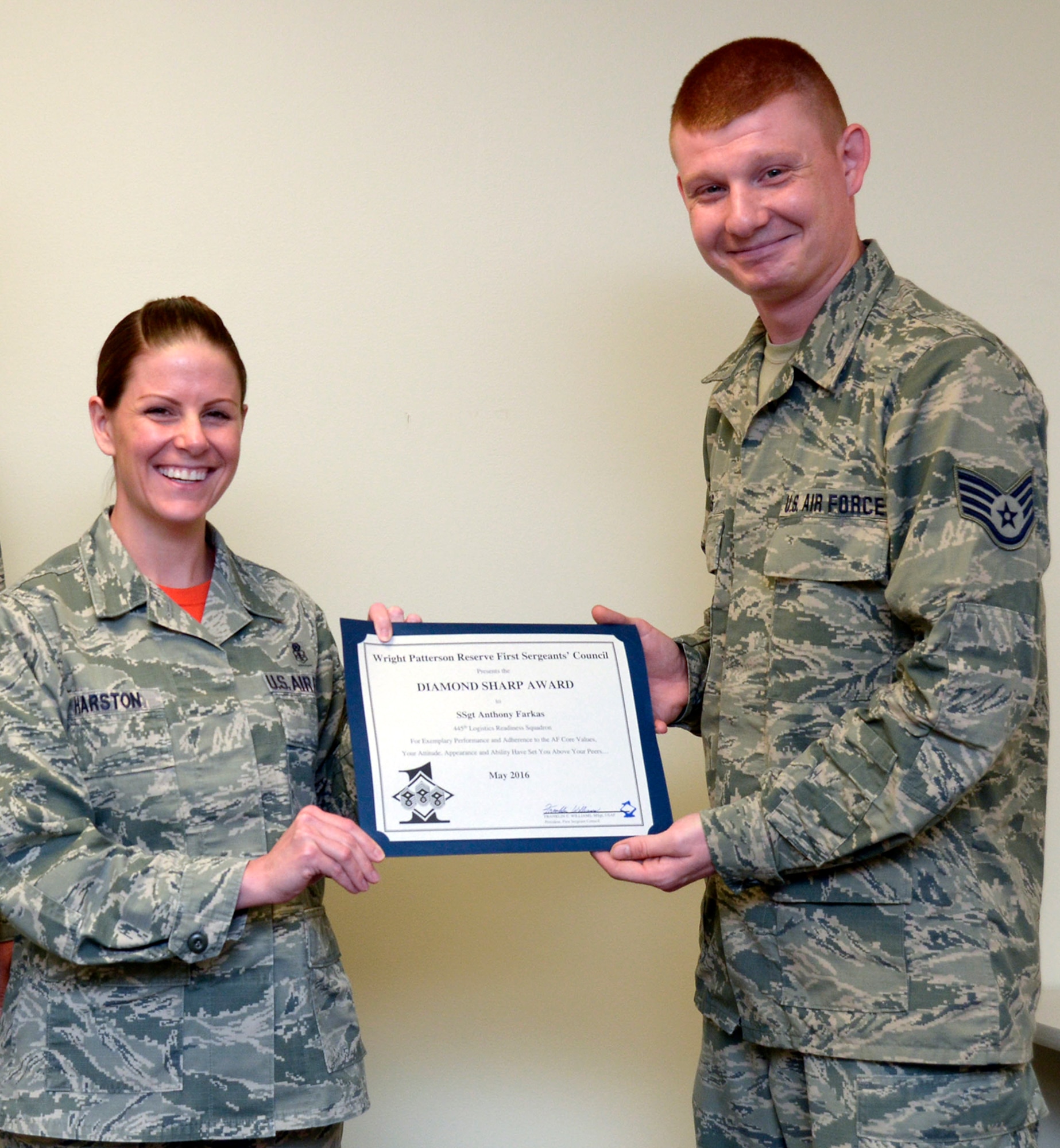 Master Sgt. Lauren B. Harston, 445th Logistics Readiness Squadron first sergeant, presents the Wright-Patterson Reserve First Sergeant’s Council Diamond Sharp Award to Staff Sgt. Anthony J. Farkas, a warehouse specialist from the 445th LRS. 