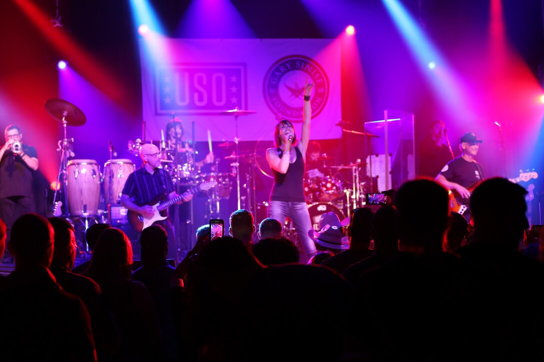 Molly Callinan (center), a member of the Lt. Dan Band, sings for the crowd during a performance on the Two Rivers Theater stage at Marine Corps Air Station Cherry Point, N.C., July 5, 2016. Gary Sinise and the Lt. Dan Band have participated in 70 United Service Organization tours since they came together. In total, they have entertained more than 363,000 service members and military families in 13 countries. The band puts on shows to raise spirits, funds and awareness for severely wounded warriors in need. Callinan is a vocalist for the Lt. Dan Band. Callinan is a vocalist with Gary Sinise and the Lt. Dan Band. (U.S. Marine Corps photo by Lance Cpl. Mackenzie Gibson/Released)