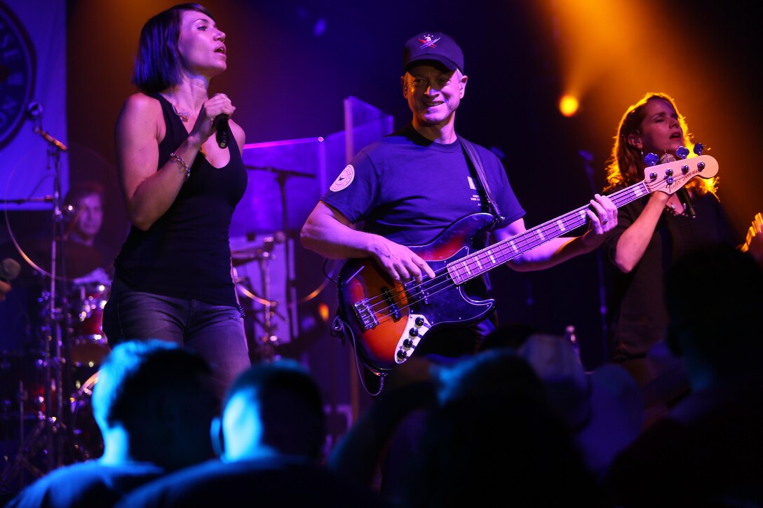 Molly Callinan (left) and Gary Sinise perform for a roaring crowd during a performance on the Two Rivers Theater stage at Marine Corps Air Station Cherry Point, N.C., July 5, 2016. Gary Sinise and the Lt. Dan Band have participated in 70 United Service Organization tours since they came together. In total, they have entertained more than 363,000 service members and military families in 13 countries. The band puts on shows to raise spirits, funds and awareness for severely wounded warriors in need. Callinan is a vocalist and Sinise is a electric bass player with the Lt. Dan Band. (U.S. Marine Corps photo by Lance Cpl. Mackenzie Gibson/Released)