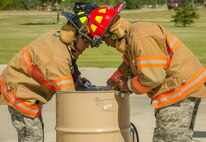 Firefighters from the 5th Civil Engineer Squadron place flags in a burn bin during a flag-burning ceremony at Minot Air Force Base, N.D., June 29, 2016. The ceremony, which takes place when worn or tattered flags need to be properly disposed of, was in honor of Flag Day. (U.S. Air Force photo/Senior Airman Apryl Hall)