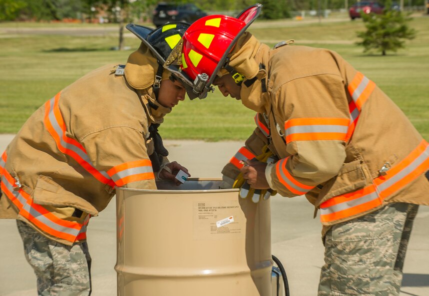 Firefighters from the 5th Civil Engineer Squadron place flags in a burn bin during a flag-burning ceremony at Minot Air Force Base, N.D., June 29, 2016. The ceremony, which takes place when worn or tattered flags need to be properly disposed of, was in honor of Flag Day. (U.S. Air Force photo/Senior Airman Apryl Hall)