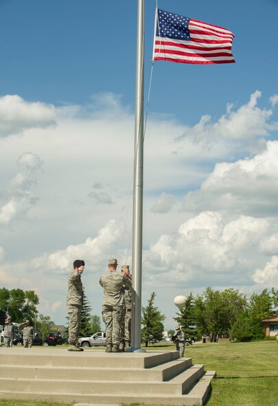 Airman Leadership School class 16-E graduates lower the flag during a formal Retreat Ceremony at Minot Air Force Base, N.D., June 29, 2016. The ALS graduates partnered with members of the Top 3 organization for the ceremony. (U.S. Air Force photo/Senior Airman Apryl Hall)