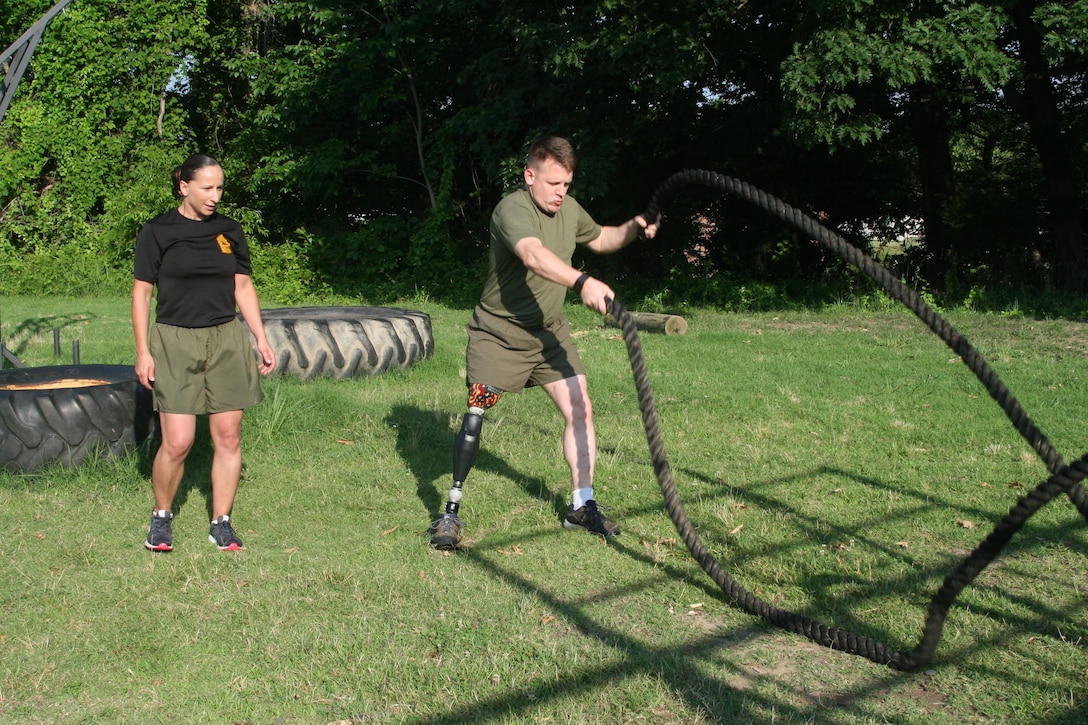 Master Sgt. Berle Sigman, a student in the Faculty Advisors Course at the Quantico Staff Non-Commissioned Officer Academy, completes a High Intensity Tactical Training physical training session aboard Marine Corps Base Quantico, June 27, with Master Gunnery Sgt. Amber Hecht, a lead instructor in the FAC. Sigman, whose original Military Occupational Specialty was 0369 Infantryman, will teach warfighting classes at the SNCO Academy after he gradutes from the course on June 29. He was injured in Ramadi, Iraq in 2004, leading to the loss of his leg.