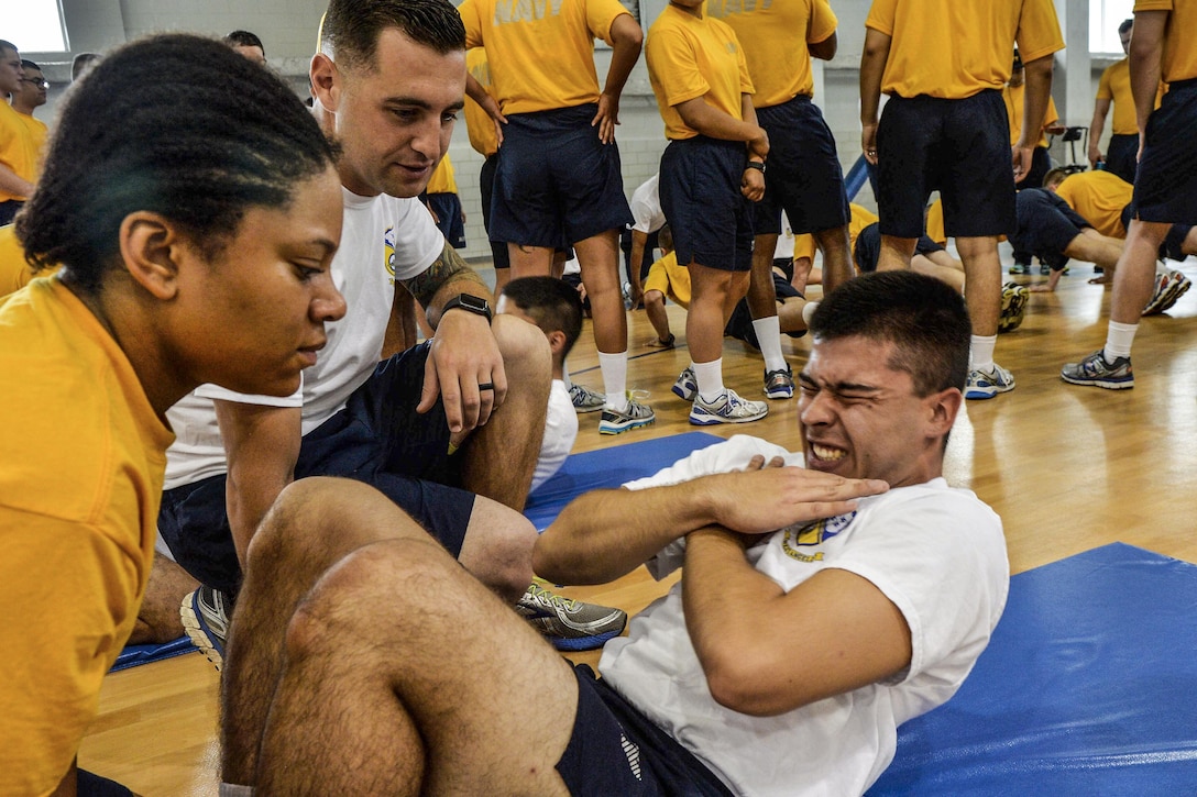 Navy Petty Officer 1st Class Michael Errichiello motivates Seaman Recruit Sean Murray to perform situps at Recruit Training Command in Great Lakes, Ill., July 1, 2016. Errichiello is assigned to the Blue Angels, the Navy's flight demonstration squadron, which participates in the Recruit Division Sponsorship Program. It allows Navy commands to interact with recruits during training and take part in turning individuals into well-rounded sailors. Navy photo by Petty Officer 2nd Class Ian Cotter