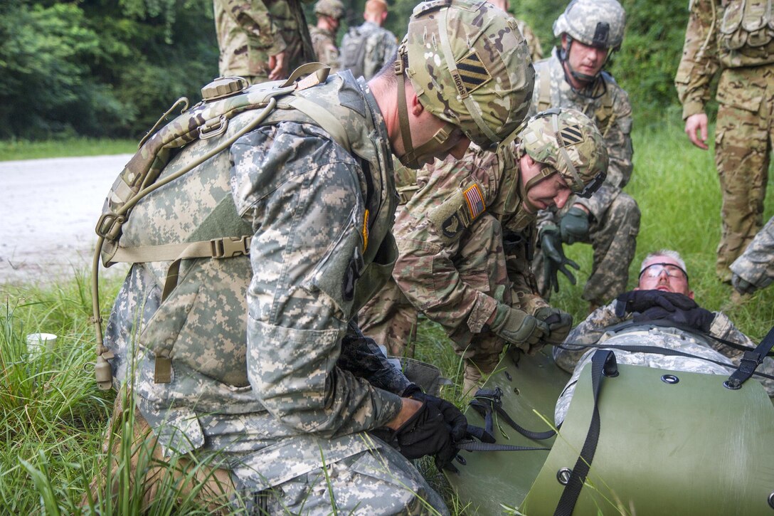 Soldiers load a simulated casualty onto a stretcher before a crew hoists it to a HH-60M Black Hawk helicopter during a tactical medical exercise at Hunter Army Airfield in Savannah, Ga., June 28, 2016. Army photo by Spc. Scott Lindblom 