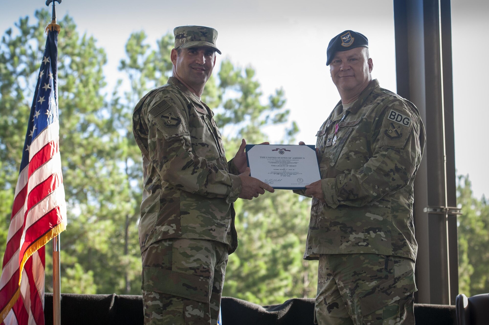 U.S. Air Force Col. Jeffery Valenzia, 93d Air Ground Operations Wing commander, presents the Legion of Merit award to Col. Michael Ross, outgoing 820th Base Defense Group commander, during a change of command ceremony, July 7, 2016, at Moody Air Force Base, Ga. During his command, Ross led four squadrons comprised of more than 680 Airmen. (U.S. Air Force photo by Airman 1st Class Lauren M. Hunter/Released)