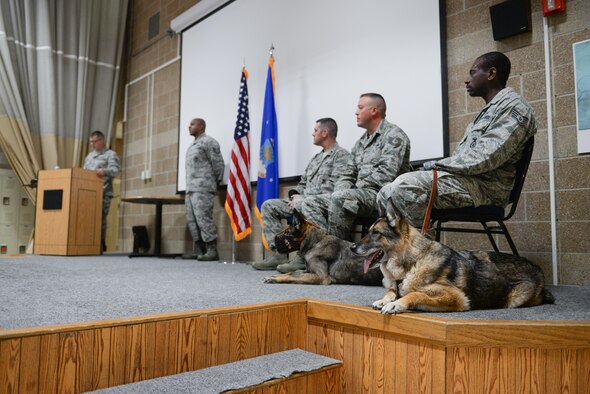 Military working dogs Ada, left, and Tex lie on the stage of the guard mount room during their retirement ceremony at the 55th Security Forces Squadron at Offutt Air Force Base, Neb., June 28, 2016. Both dogs have been deployed numerous times during their service at Offutt, and have both seen combat. (U.S. Air Force photo/Zach Hada)
