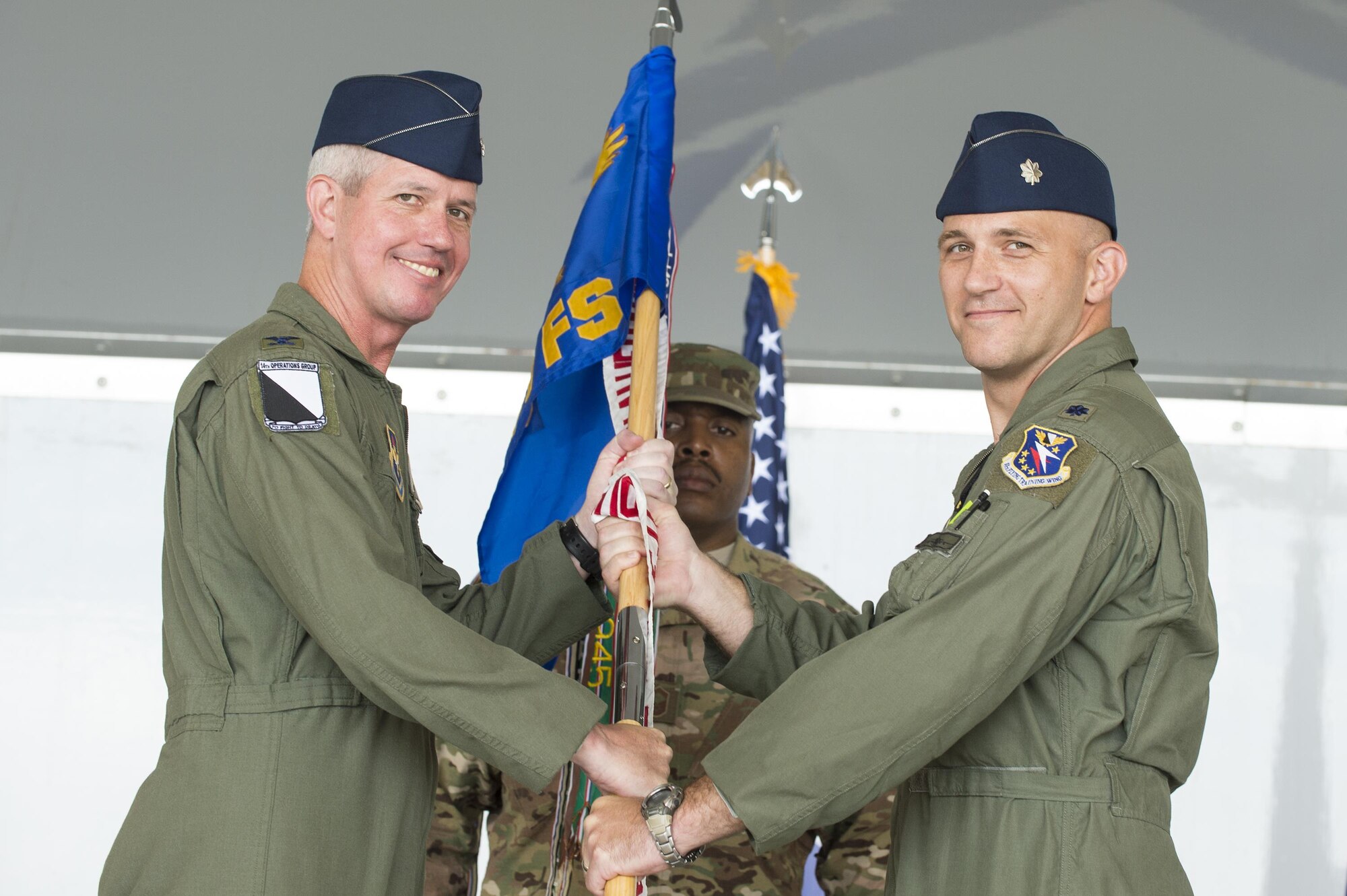 U.S. Air Force Col. James Boster, 14th Operations Group commander, and Lt. Col. Ryan Hill, 81st Fighter Squadron incoming commander, pose for a photo, during a change of command ceremony, July 7, 2016, at Moody Air Force Base, Ga. The 81st FS reactivated in January 2015 as a part of the 14th Flying Training Wing and currently conducts training operations as a tenant unit at Moody. (U.S. Air Force photo by Senior Airman Ceaira Tinsley/ Released)