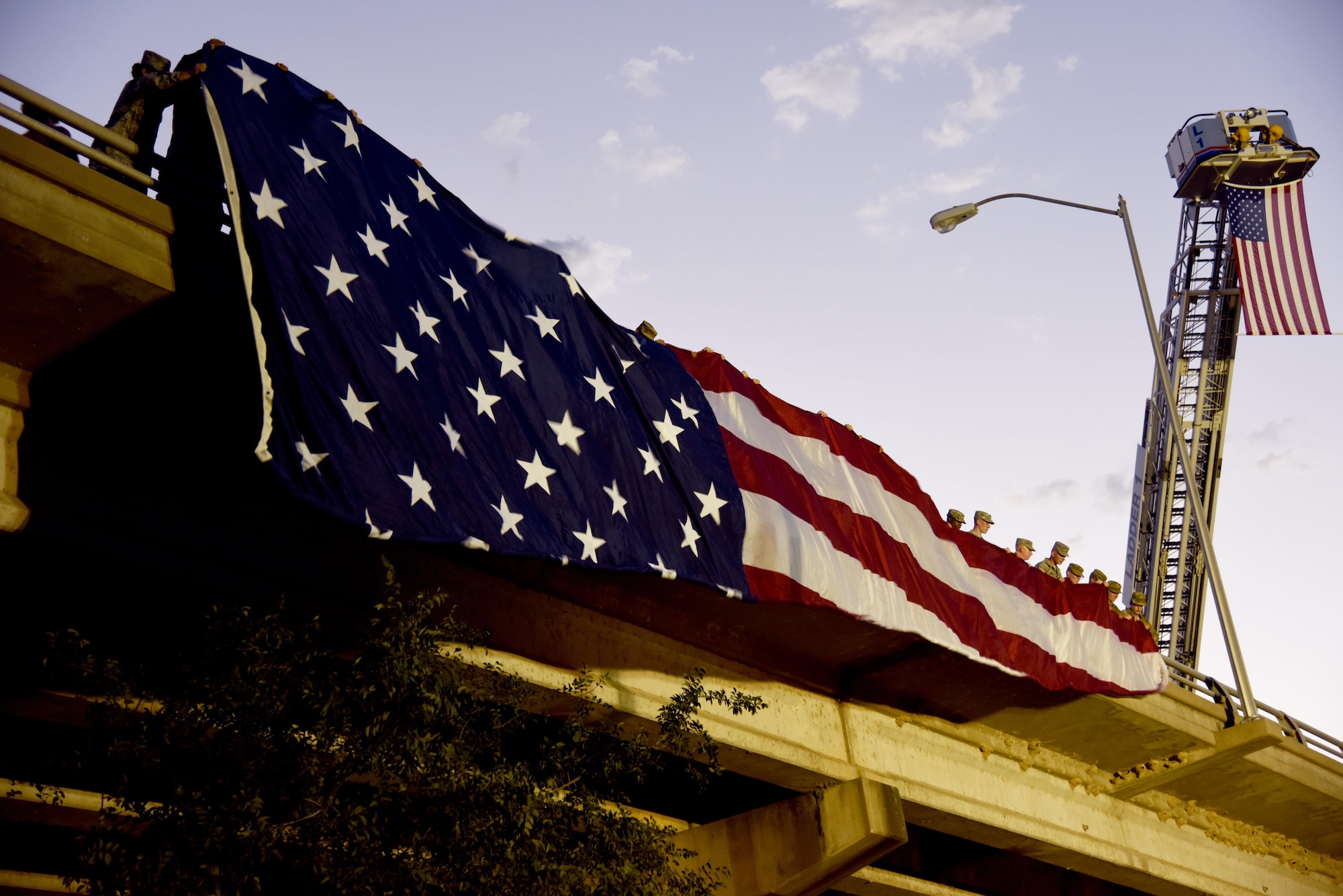 Goodfellow Air Force Base Soldiers and Airmen unravel an American flag during the 29th Annual San Angelo Symphony July 3rd Pops Concert at the Bill Aylor Sr. Memorial RiverStage in San Angelo, Texas, July 3, 2016. The concert attracted over 35,000 people and is now the fourth-largest in the state. (U.S. Air Force photo by Senior Airman Joshua Edwards/Released)