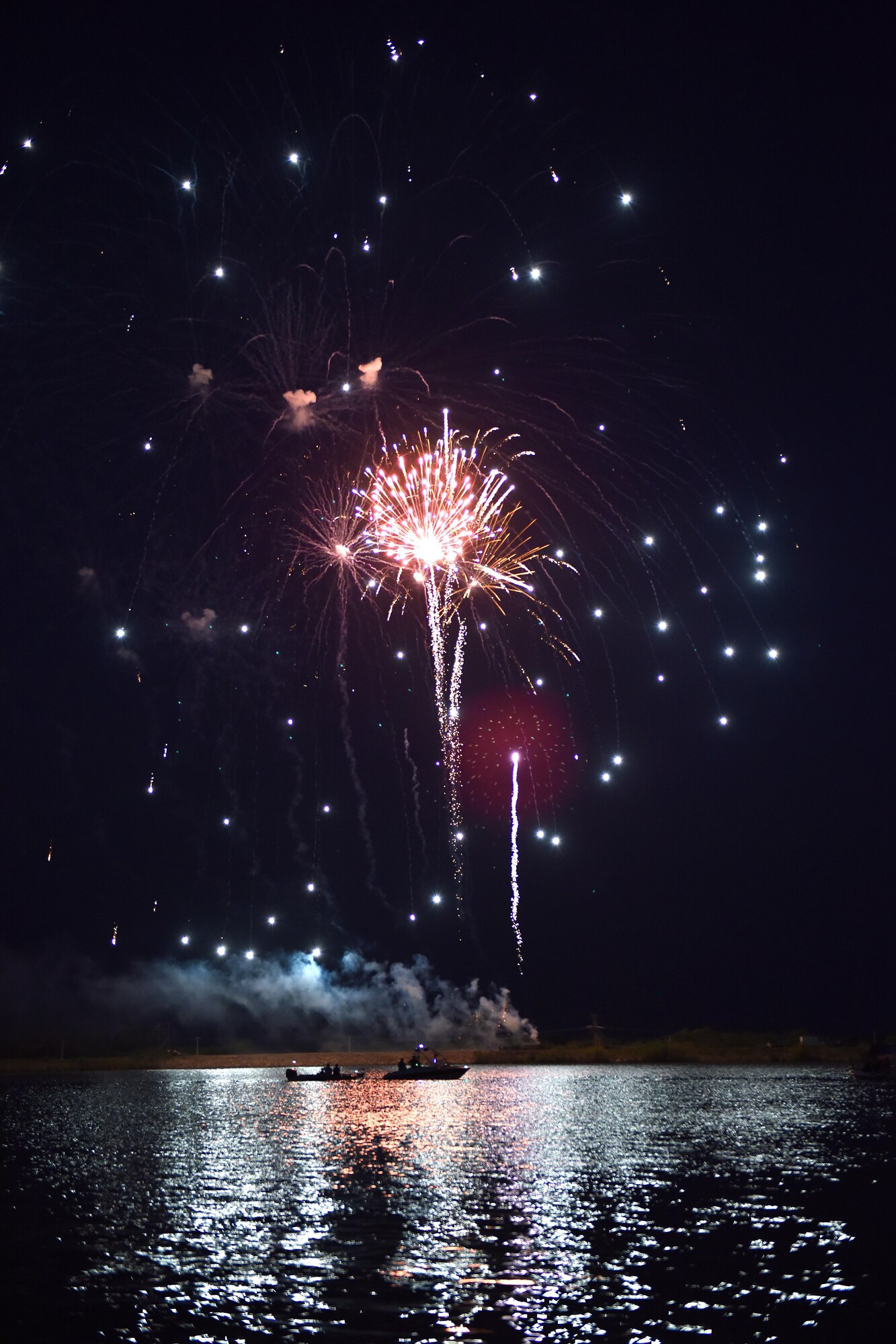 Fireworks explode over boats on Lake Nasworthy during the 4th of July Celebration in San Angelo, Texas, July 4, 2016. Participants could rent boats or sit alongside the bank of Lake Nasworthy to view the fireworks display. (U.S. Air Force photo by Airman 1st Class Caelynn Ferguson/Released)