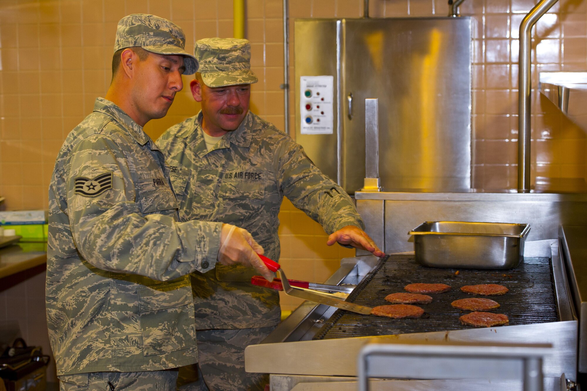 Staff Sgt. Alan Reese and Staff Sgt. Allan Parra, 926th Force Support Squadron service apprentices, prepare hamburger patties on a grill May 13, 2016, at the Crosswinds Dining Facility. The training for the 926th FSS Airmen is to provide additional tools to help them be successful in progressing.