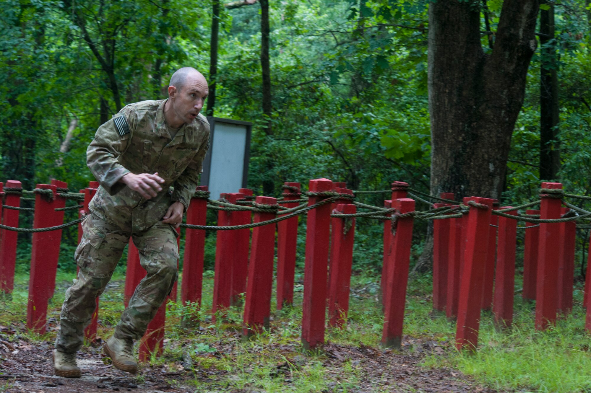 Senior Master Sgt. Kevin Hammer, 87th Civil Engineer Squadron's Explosive Ordnance Disposal Flight chief, rushes through a rope maze at the Fort Dix obstacle course during the service member of the year competition at Joint Base McGuire-Dix-Lakehurst, New Jersey, June 28, 2016. The obstacle course included a rope climb, log walks, wall jumps, tunnel run and monkey bars.



