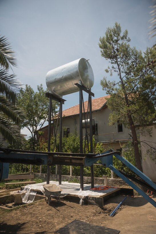 Airmen from the 107th Civil Engineer Squadron, Niagara Falls Air Reserve Station, N.Y., engineer a support structure to mount a 5,000 liter water tank to in order to ensure the clinic in Vau Dejes, Albania, always has a source of running water, June 18-July 2, 2016. The Airmen did such renovations as replacing walls, windows and doors as part of a Deployment For Training. (U.S. Air Force Photo by Staff Sgt. Ryan Campbell/released)