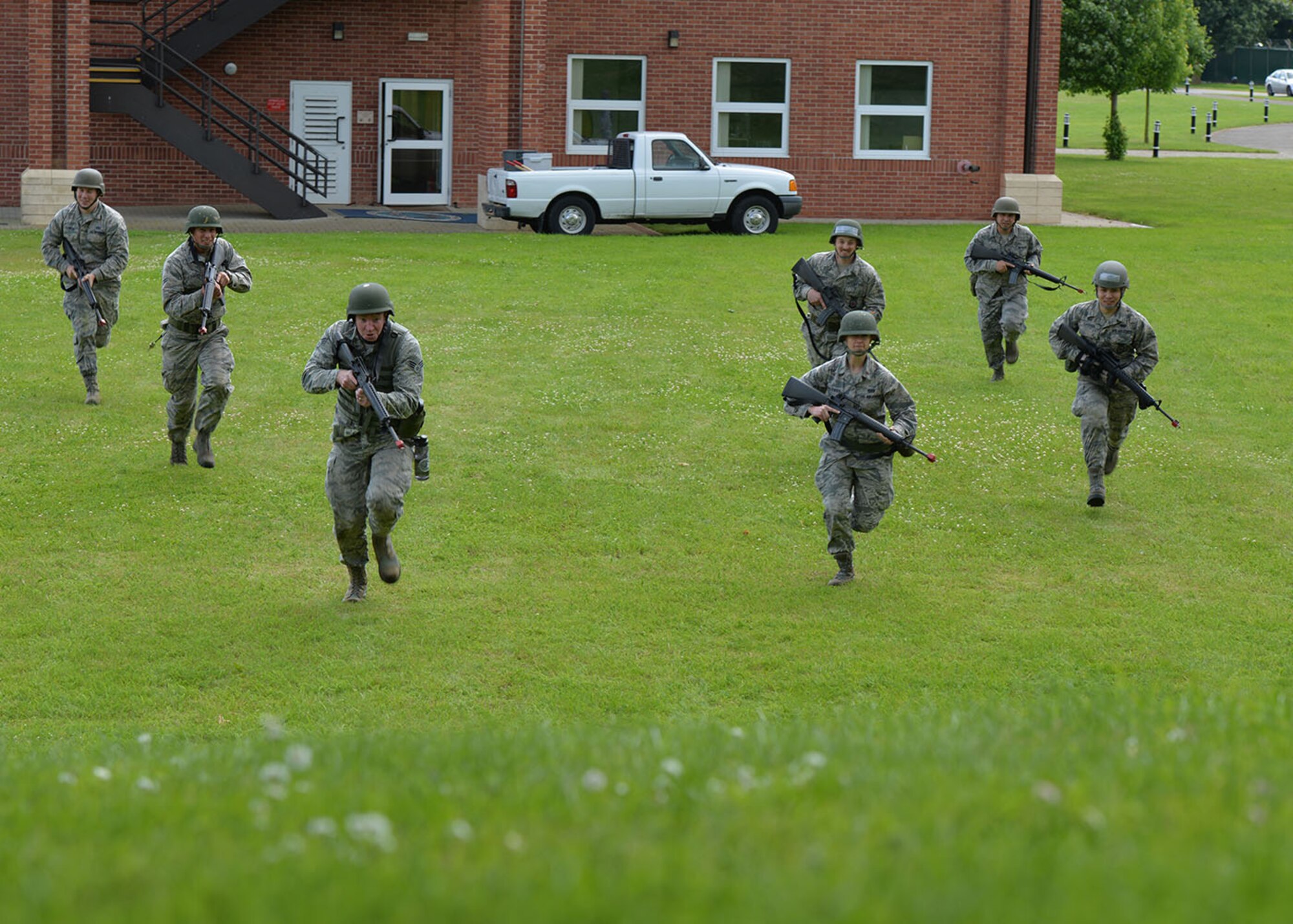 A chalk of U.S. Air Force Airmen storm a hill before practicing low- and high-crawling with a weapon during Prime Base Engineer Exercise Force training June 30, 2016, on RAF Mildenhall, England. Airmen from the 100th CES trained on a variety of equipment and situations, including driving a Humvee, operating heavy machinery, land navigation, and high- and low-crawling, to prepare them for a deployed environment. (U.S. Air Force photo by Karen Abeyasekere/Released)