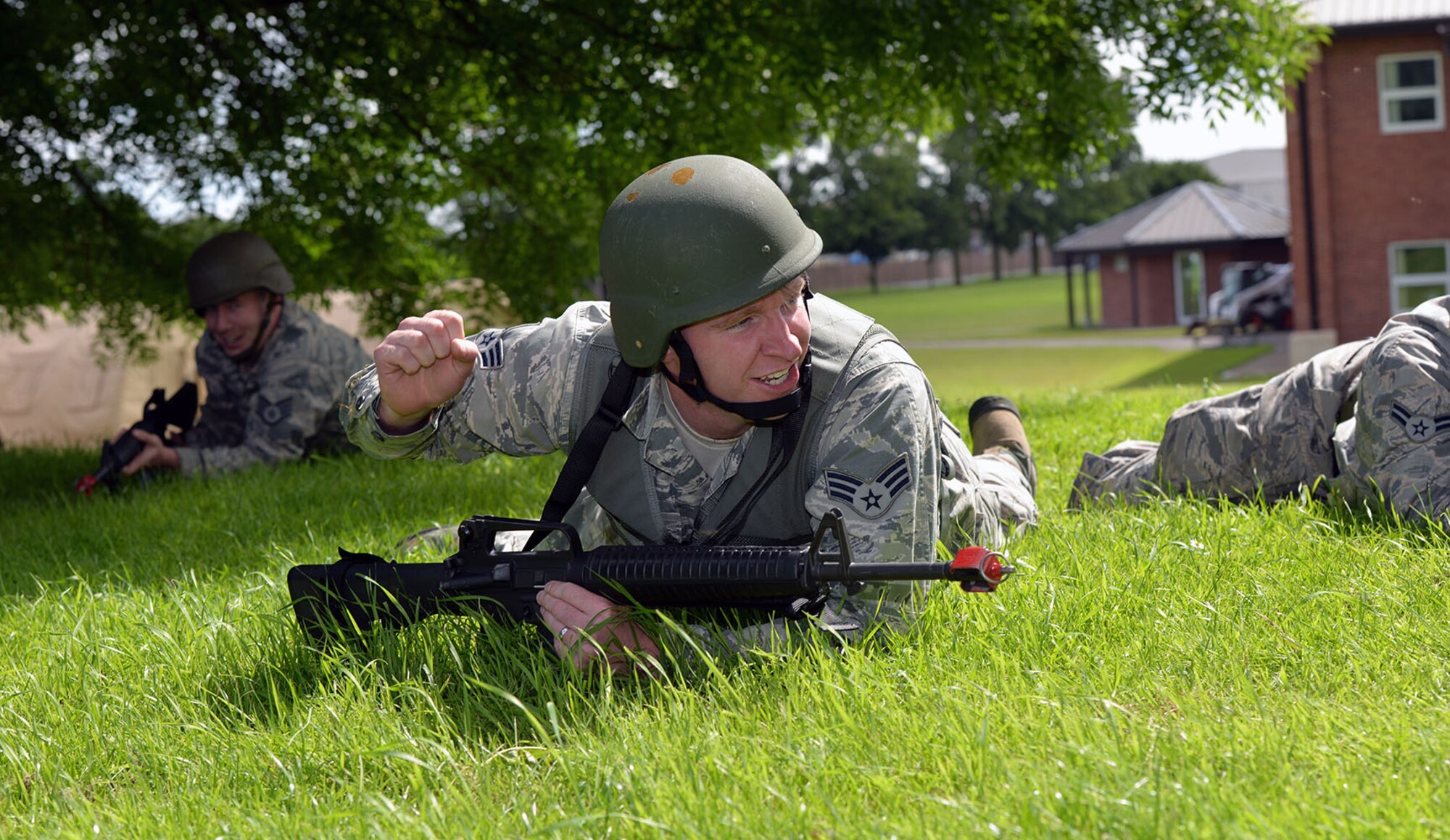 U.S. Air Force Senior Airman Jake Brown, 100th Civil Engineer Squadron Readiness and Emergency Management journeyman, shouts instructions to his team as they high- and low-crawl up a hill as part of Prime Base Engineer Exercise Force training June 30, 2016, on RAF Mildenhall, England. The training is held annually and provides the 100th CES Airmen with the knowledge and hands-on experience to prepare them for a deployed environment. (U.S. Air Force photo by Karen Abeyasekere/Released)
