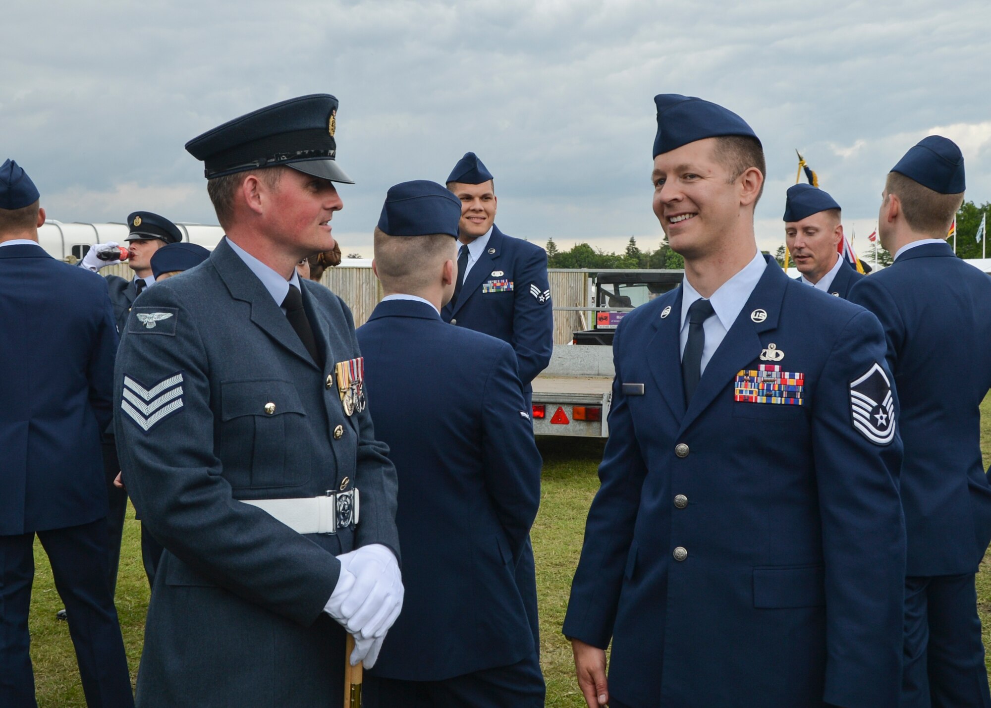 Chief Tech. Paul Upson, Royal Air Force Marham avionics technician, talks with Master Sgt. Trevor Gilliand, 48th Operations Support group air crew flight equipment superintendent, before marching at the Royal Norfolk Show in Norfolk, England, June 30. Members from U.S. branches used downtime before marching to talk with U.K. partners. (U.S. Air Force photo/Senior Airman Nigel Sandridge)