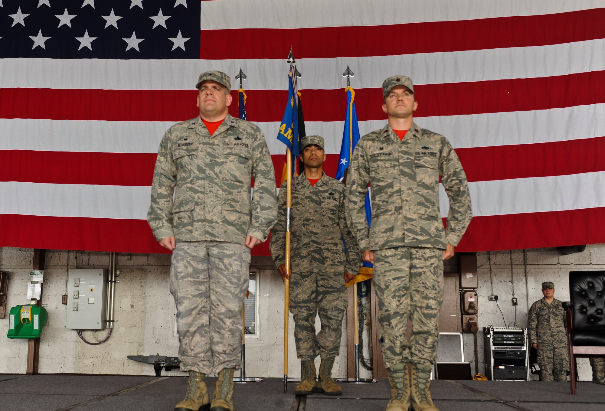 U.S. Air Force Col. Stephen Scherzer, 52nd Maintenance Group commander, left, and U.S. Air Force Maj. John Szczepanski, incoming 52nd Aircraft Maintenance Squadron commander, right, stand at attention while U.S. Air Force Master Sgt. Jason Riter, 52nd MXG first sergeant, center, holds the 52nd AMXS guidon during an assumption of command ceremony at Hangar One on Spangdahlem Air Base, Germany, July 8, 2016.  The 52nd AMXS aims to provide fully mission capable aircraft through safe and professional maintenance. (U.S. Air Force Photo by Staff Sgt. Joe W. McFadden/Released)