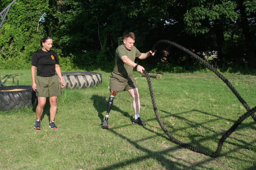 Master Sgt. Berle Sigman, a student in the Faculty Advisors Course (FAC) at the Quantico Staff Non-Commissioned Officer (SNCO) Academy, completes a High Intensity Tactical Training (HITT) physical training session aboard Marine Corps Base Quantico June 27 with Master Gunnery Sgt. Amber Hecht, a lead instructor in the FAC. Sigman, whose original Military Occupational Specialty was 0369 Infantryman, will teach warfighting classes at the SNCO Academy after he gradutes from the course on June 29. He was injured in Ramadi, Iraq in 2004, leading to the loss of his leg.