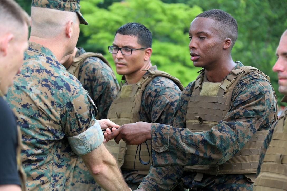 Cpl. Duane Levy, right, receives his Marine Corps Martial Arts instructor belt from Lt. Col. Bret Hyla after completing the four-and-a-half mile endurance course of a MCMAI Course at Marine Corps Air Station Cherry Point, N.C., July 1, 2016. The endurance course was the culminating event of three weeks of physical, mental, and character challenges Marines assigned to MWCS-28 completed to earn their instructor tabs. MCMAP is a combat system that trains Marines in the art of hand-to-hand and close quarters combat techniques while building morale and team-building functions. This MCMAP instructor course was conducted by the unit to certify Marines with the responsibility of instructing and training Marines in MCMAP. MWCS-28 is one of the squadrons assigned to Marine Air Control Group 28, 2nd Marine Aircraft Wing. (U.S. Marine Corps photo by Cpl. N.W. Huertas/Released)