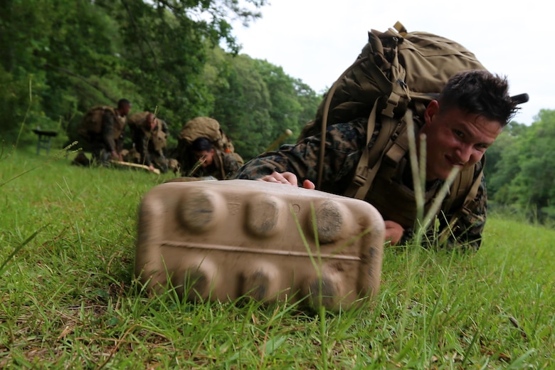 Sgt. James Metzgar crawls through a field with his gear during the four-and-a-half mile endurance course of a Marine Corps Martial Arts Instructor Course at Marine Corps Air Station Cherry Point, N.C., July 1, 2016. The endurance course was the culminating event of three weeks of physical, mental, and character challenges Marines assigned to Marine Wing Communications Squadron 28 completed to earn their instructor tabs. MCMAP is a combat system that trains Marines in the art of hand-to-hand and close quarters combat techniques while building morale and teamwork. This MCMAP instructor course was conducted by the unit to certify Marines with the responsibility of instructing and training Marines in MCMAP. Metzgar is a cyber-network operator assigned to MWCS-28, Marine Air Control Group 28, 2nd Marine Aircraft Wing. (U.S. Marine Corps photo by Cpl. N.W. Huertas/Released)