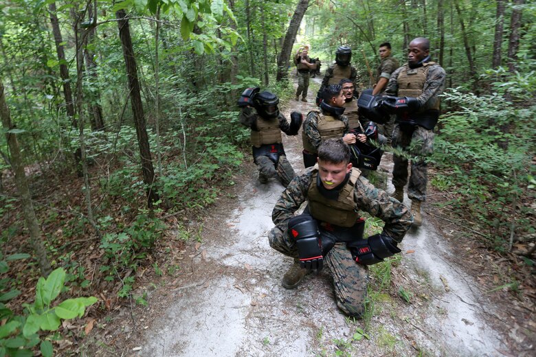 Marines with Marine Wing Communication Squadron 28 adjust their gear prior to an exercise during the four-and-a-half mile endurance course of a Marine Corps Martial Arts Instructor Course at Marine Corps Air Station Cherry Point, N.C., July 1, 2016. The endurance course was the culminating event of three weeks of physical, mental, and character challenges Marines assigned to MWCS-28 completed to earn their instructor tabs. MCMAP is a combat system that trains Marines in the art of hand-to-hand and close quarters combat techniques while building morale and team-building functions. This MCMAP instructor course was conducted by the unit to certify Marines with the responsibility of instructing and training Marines in MCMAP. (U.S. Marine Corps photo by Cpl. N.W. Huertas/Released)