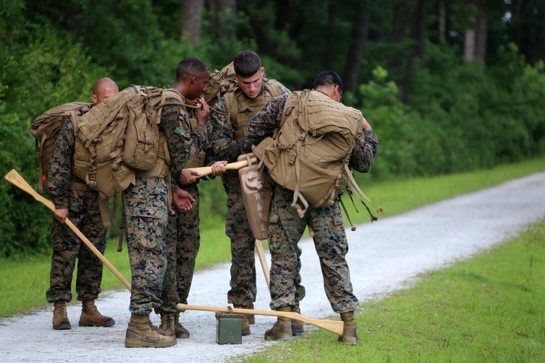 Marines with Marine Wing Communication Squadron 28 gather their gear during the four-and-a-half mile endurance course of a Marine Corps Martial Arts Instructor Course at Marine Corps Air Station Cherry Point, N.C., July 1, 2016. The endurance course was the culminating event of three weeks of physical, mental, and character challenges Marines assigned to MWCS-28 completed to earn their instructor tabs. MCMAP is a combat system that trains Marines in the art of hand-to-hand and close quarters combat techniques while building morale and teamwork. This MCMAP instructor course was conducted by the unit to certify Marines with the responsibility of instructing and training Marines in MCMAP. MWCS-28 is one of the squadrons assigned to Marine Air Control Group 28, 2nd Marine Aircraft Wing (U.S. Marine Corps photo by Cpl. N.W. Huertas/Released)