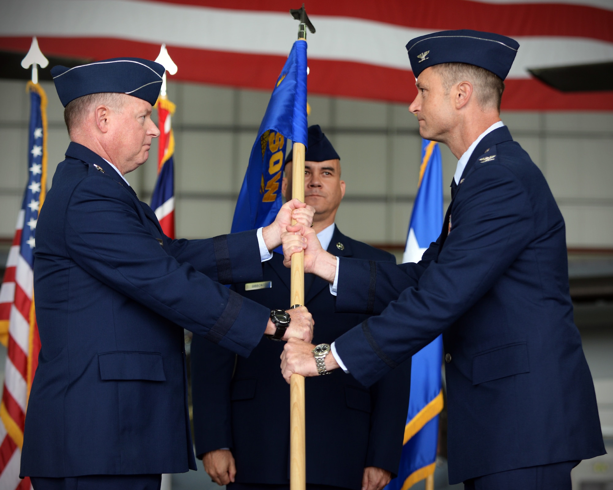 U.S. Air Force Maj. Gen. Eugene Haase, Air Force Special Operations Command vice commander passes the guidon to U.S. Air Force Col. Matthew Smith, 352nd Special Operations Wing incoming commander during the 352 SOW change of command ceremony July 8, 2016, on RAF Mildenhall, England. Smith took command of the 352nd SOW following U.S. Air Force Col. William Holt’s departure as part of routine military assignment rotations. (U.S. Air Force photo by Senior Airman Christine Halan/Released)