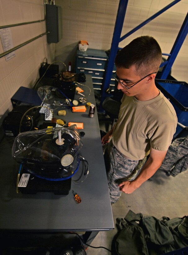 Airman 1st Class Maxwell Dean, a material management apprentice with the 1st Special Operations Logistics Readiness Squadron, oversees a gas mask seal test at Hurlburt Field, Fla., July 7, 2016. A Joint Service Mask Leakage tester monitors aerosol vapor under a gas mask shroud to check masks for leaks and blocks. (U.S. Air Force photo by Senior Airman Andrea Posey)