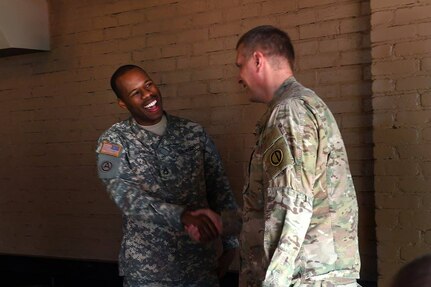 Sgt. 1st Class Terence Barron, left, shakes hands with Lt. Col. Jeffrey Carter, G3, during a farewell luncheon for Barron. Barron was an Active/Guard-Reserve soldier assigned to the command in the G1/Personnel and G3/Operations shops. Barron was re-assigned and is preparing for an upcoming deployment.
 (Photo by Mr. Anthony L. Taylor)