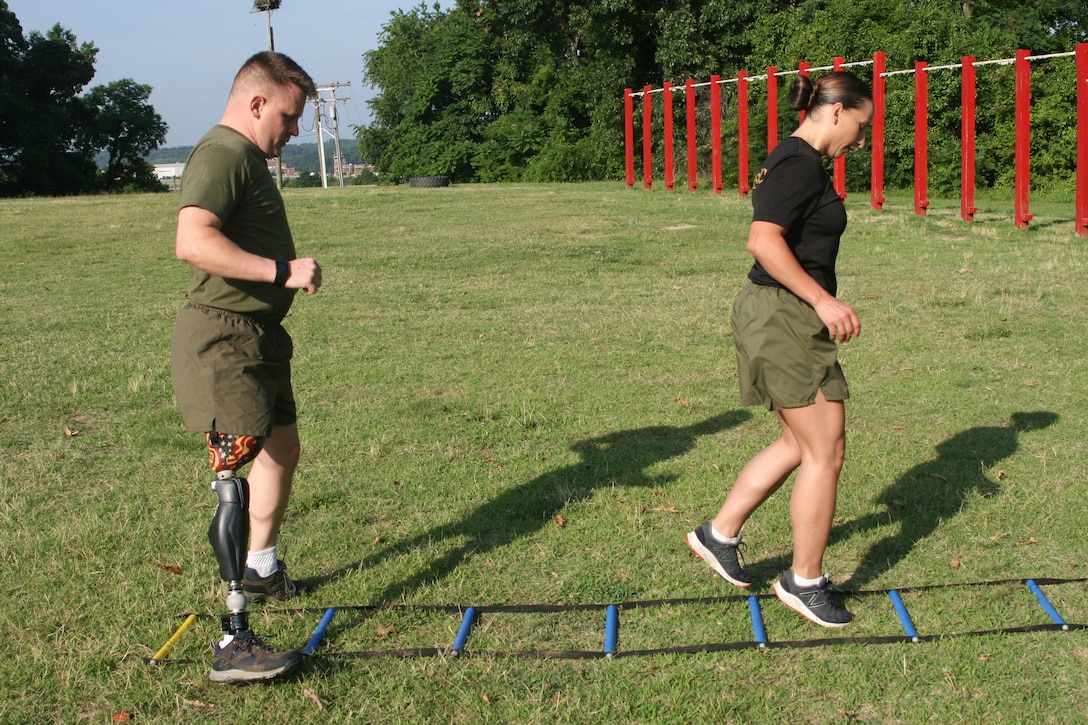 Master Sgt. Berle Sigman, a student in the Faculty Advisors Course (FAC) at the Quantico Staff Non-Commissioned Officer (SNCO) Academy, completes a High Intensity Tactical Training (HITT) physical training session aboard Marine Corps Base Quantico June 27 with Master Gunnery Sgt. Amber Hecht, a lead instructor in the FAC. Sigman, whose original Military Occupational Specialty was 0369 Infantryman, will teach warfighting classes at the SNCO Academy after he graduates from the course on June 29. He was injured in Ramadi, Iraq in 2004, leading to the loss of his leg.
